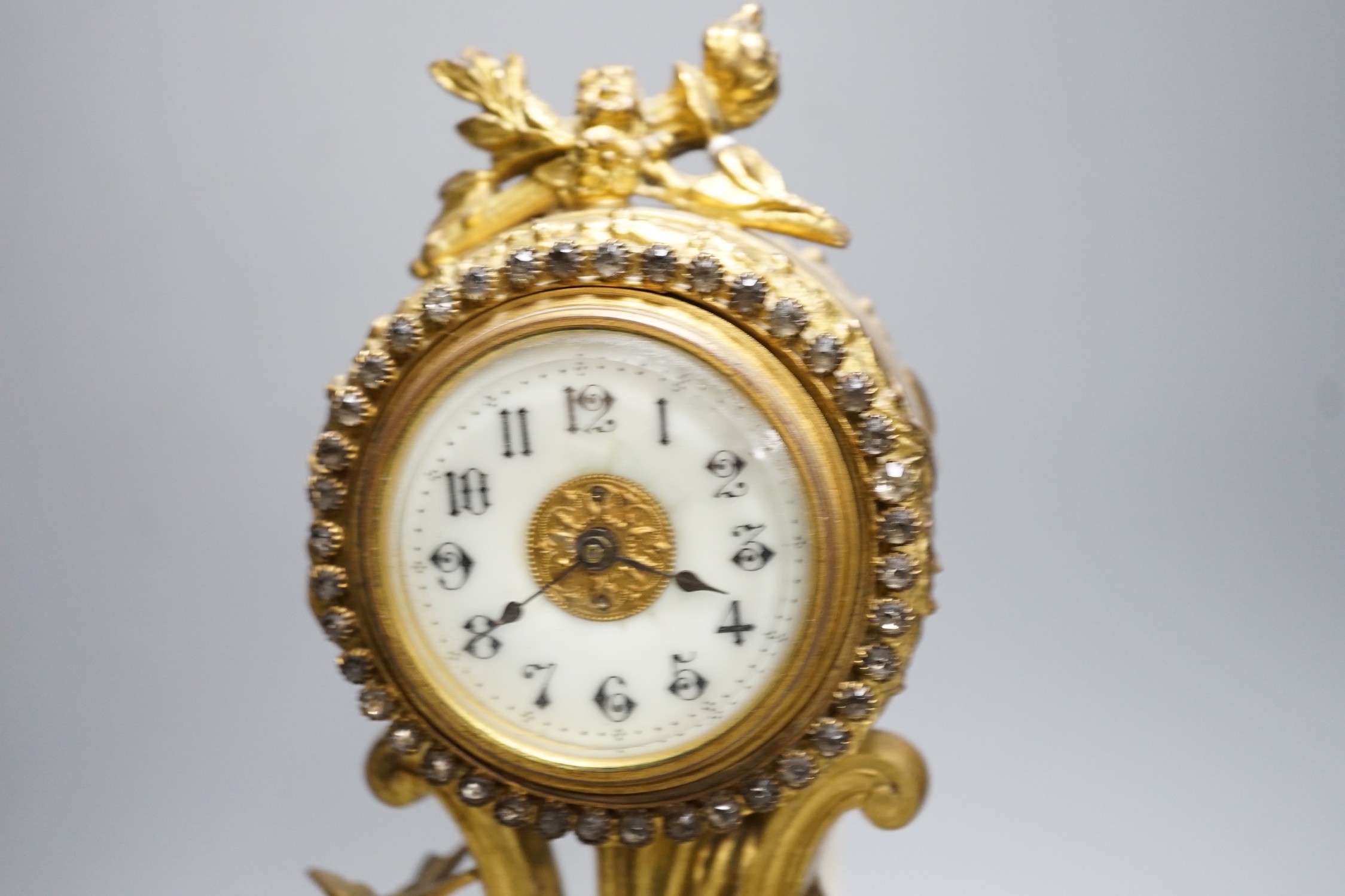 An early 20th century gilt metal cherubic mantel timepiece on onyx base, 29cm